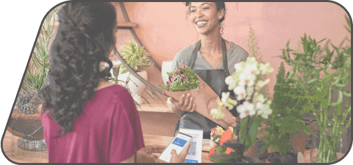 client paying in a flower store with a credit card reader tapping with her phone.