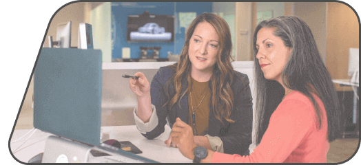 2 woman sitting next to a laptop in their office discussing PEO providers